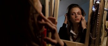 Movie still from “Kidulthood” (2006), directed by Menhaj Huda – A girl is putting her hair in front of a mirror; Close Up shot, Low angle