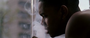 Movie still from “Kidulthood” (2006), directed by Menhaj Huda – A man smoking a cigarette in front of a window; Close Up shot, Low angle