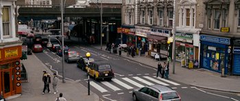 Movie still from “Kidulthood” (2006), directed by Menhaj Huda – A busy city street with cars and people walking on the sidewalk; Extreme Wide shot, High angle