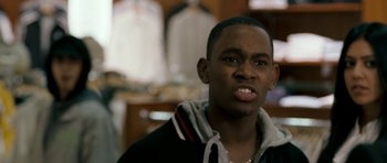 Movie still from “Kidulthood” (2006), directed by Menhaj Huda – A man in a black jacket is looking at the camera; Close Up shot, Over the shoulder angle