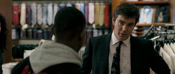 Movie still from “Kidulthood” (2006), directed by Menhaj Huda – A man in a suit talking to another man in a suit; Medium shot, Over the shoulder angle
