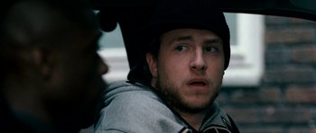 Movie still from “Kidulthood” (2006), directed by Menhaj Huda – A person wearing a hat; Close Up shot, Over the shoulder angle