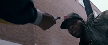 Movie still from “Kidulthood” (2006), directed by Menhaj Huda – A man holding a knife up to a man's face; Close Up shot, Over the shoulder angle