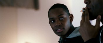 Movie still from “Kidulthood” (2006), directed by Menhaj Huda – A young man's face in a room; Close Up shot, Over the shoulder angle
