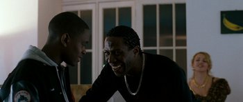 Movie still from “Kidulthood” (2006), directed by Menhaj Huda – Two men are smiling and talking to each other; Close Up shot, Over the shoulder angle