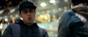 Movie still from “Kidulthood” (2006), directed by Menhaj Huda – A man in a black hat and a black jacket; Close Up shot, Low angle