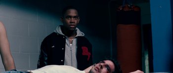 Movie still from “Kidulthood” (2006), directed by Menhaj Huda – Two men standing next to each other in front of a bed; Medium shot, High angle