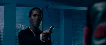 Movie still from “Kidulthood” (2006), directed by Menhaj Huda – A man holding a cell phone in his hand; Close Up shot, Low angle