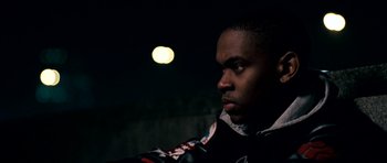 Movie still from “Kidulthood” (2006), directed by Menhaj Huda – A man in a black jacket is looking at the camera; Close Up shot, Low angle