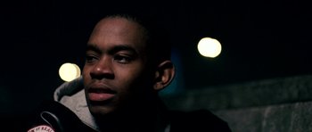 Movie still from “Kidulthood” (2006), directed by Menhaj Huda – A person wearing a jacket; Close Up shot, Over the shoulder angle