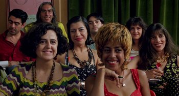 Movie still from “Kika” (1993), directed by Pedro Almodóvar – A group of people posing for a picture; Close Up shot, High angle