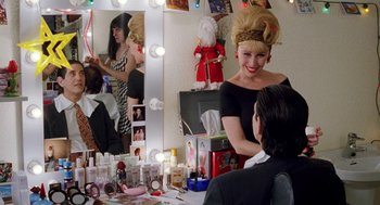 Movie still from “Kika” (1993), directed by Pedro Almodóvar – A woman is sitting in front of a mirror; Medium shot, Over the shoulder angle