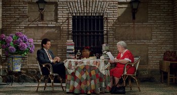 Movie still from “Kika” (1993), directed by Pedro Almodóvar – A man and a woman sitting at a dinner table; Wide shot, High angle