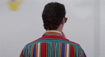 Movie still from “Kika” (1993), directed by Pedro Almodóvar – A man in a striped shirt is looking at the sky; Close Up shot, Over the shoulder angle