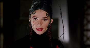 Movie still from “Kika” (1993), directed by Pedro Almodóvar – A young woman wearing a black outfit and red earrings; Close Up shot, Low angle