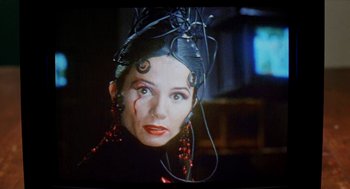 Movie still from “Kika” (1993), directed by Pedro Almodóvar – A person with wires attached to their head; Close Up shot, Over the shoulder angle