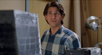 Movie still from “Kika” (1993), directed by Pedro Almodóvar – A man in a blue and white checkered shirt looking at a computer screen; Close Up shot, Over the shoulder angle