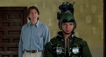 Movie still from “Kika” (1993), directed by Pedro Almodóvar – A man standing next to a woman wearing a helmet; Medium shot, Over the shoulder angle