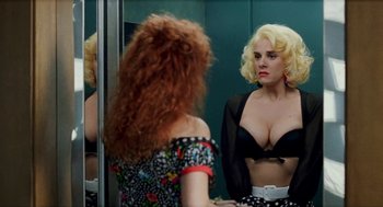 Movie still from “Kika” (1993), directed by Pedro Almodóvar – A woman is looking in the bathroom mirror; Medium shot, Over the shoulder angle