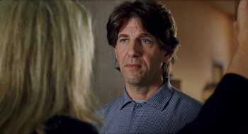 Movie still from “Kika” (1993), directed by Pedro Almodóvar – A person wearing a blue and white checkered shirt; Close Up shot, Over the shoulder angle