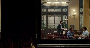 Movie still from “Kika” (1993), directed by Pedro Almodóvar – A reflection of a man in a suit in a mirror; Wide shot, Over the shoulder angle