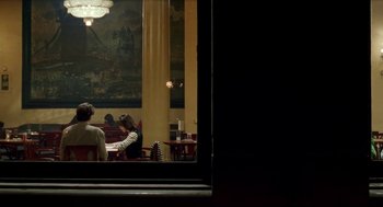 Movie still from “Kika” (1993), directed by Pedro Almodóvar – People are sitting at a table in a restaurant; Wide shot, Over the shoulder angle