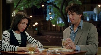 Movie still from “Kika” (1993), directed by Pedro Almodóvar – A man and a woman sitting at a table with drinks; Medium shot, Over the shoulder angle