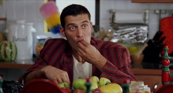 Movie still from “Kika” (1993), directed by Pedro Almodóvar – A person sitting in front of a bowl of fruit; Medium shot, Over the shoulder angle
