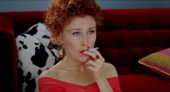 Movie still from “Kika” (1993), directed by Pedro Almodóvar – A person holding a cigarette in her mouth; Close Up shot, Overhead angle