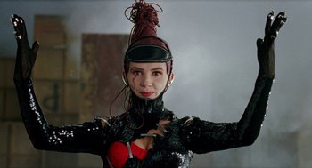 Movie still from “Kika” (1993), directed by Pedro Almodóvar – A woman wearing a black outfit and a red hat; Close Up shot, Low angle