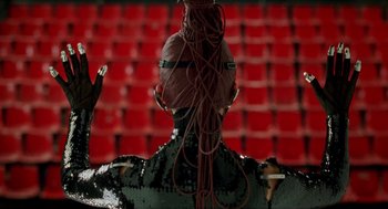 Movie still from “Kika” (1993), directed by Pedro Almodóvar – A person in a black outfit with red hair; Close Up shot, Low angle