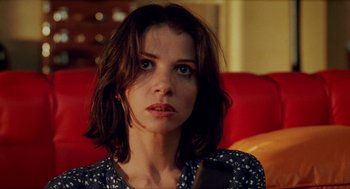 Movie still from “Kika” (1993), directed by Pedro Almodóvar – A person sitting on a couch; Close Up shot, Over the shoulder angle