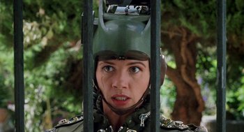 Movie still from “Kika” (1993), directed by Pedro Almodóvar – A woman wearing a green helmet is looking at the camera; Close Up shot, Low angle