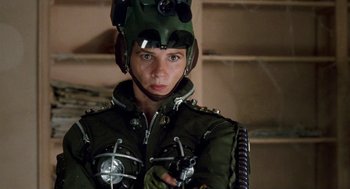 Movie still from “Kika” (1993), directed by Pedro Almodóvar – A woman wearing a helmet and holding a gun in her hand; Close Up shot, Low angle