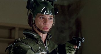 Movie still from “Kika” (1993), directed by Pedro Almodóvar – A woman wearing a helmet and holding a gun; Close Up shot, High angle