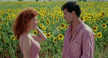 Movie still from “Kika” (1993), directed by Pedro Almodóvar – A man and a woman standing in front of a field of sunflowers; Medium shot, High angle