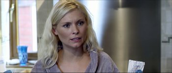 Movie still from “Kill List” (2011), directed by Ben Wheatley – A woman with blonde hair is looking to her left; Close Up shot, Over the shoulder angle