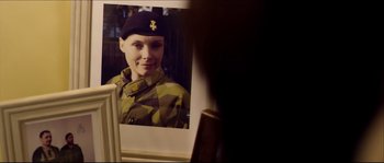 Movie still from “Kill List” (2011), directed by Ben Wheatley – A woman in a military uniform looking into a mirror; Close Up shot, Over the shoulder angle