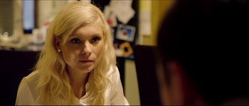 Movie still from “Kill List” (2011), directed by Ben Wheatley – A woman sitting in front of a mirror looking at the camera; Close Up shot, Over the shoulder angle