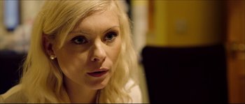 Movie still from “Kill List” (2011), directed by Ben Wheatley – A person with blonde hair; Close Up shot, Over the shoulder angle