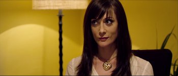 Movie still from “Kill List” (2011), directed by Ben Wheatley – A person wearing a necklace; Close Up shot, Over the shoulder angle