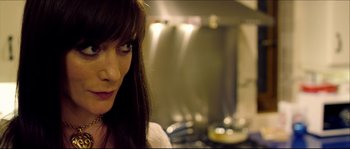 Movie still from “Kill List” (2011), directed by Ben Wheatley – A woman's face in front of a stove; Close Up shot, Over the shoulder angle