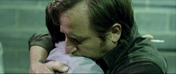 Movie still from “Kill List” (2011), directed by Ben Wheatley – A person kissing another person on the cheek; Close Up shot, Over the shoulder angle