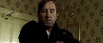 Movie still from “Kill List” (2011), directed by Ben Wheatley – A person wearing a jacket; Close Up shot, Low angle