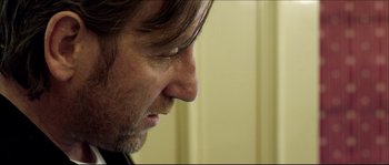 Movie still from “Kill List” (2011), directed by Ben Wheatley – A man's face as he looks to his left; Close Up shot, Over the shoulder angle