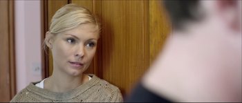 Movie still from “Kill List” (2011), directed by Ben Wheatley – A woman in a beige sweater is looking at a man in a blue shirt; Close Up shot, Over the shoulder angle