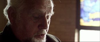 Movie still from “Kill List” (2011), directed by Ben Wheatley – An old man with a beard and a white mustache; Close Up shot, Low angle