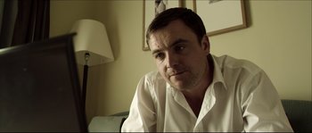 Movie still from “Kill List” (2011), directed by Ben Wheatley – A person wearing a white shirt; Close Up shot, Over the shoulder angle