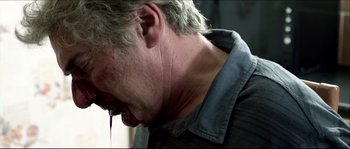 Movie still from “Kill List” (2011), directed by Ben Wheatley – A person's face and neck; Close Up shot, Low angle