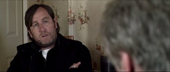 Movie still from “Kill List” (2011), directed by Ben Wheatley – A man in a black jacket talking to another man in a black jacket; Close Up shot, Over the shoulder angle